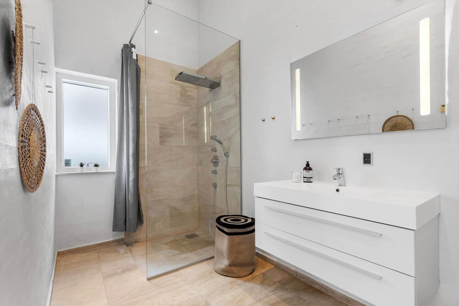 Bad mit Dusche, Waschbecken und Spiegel