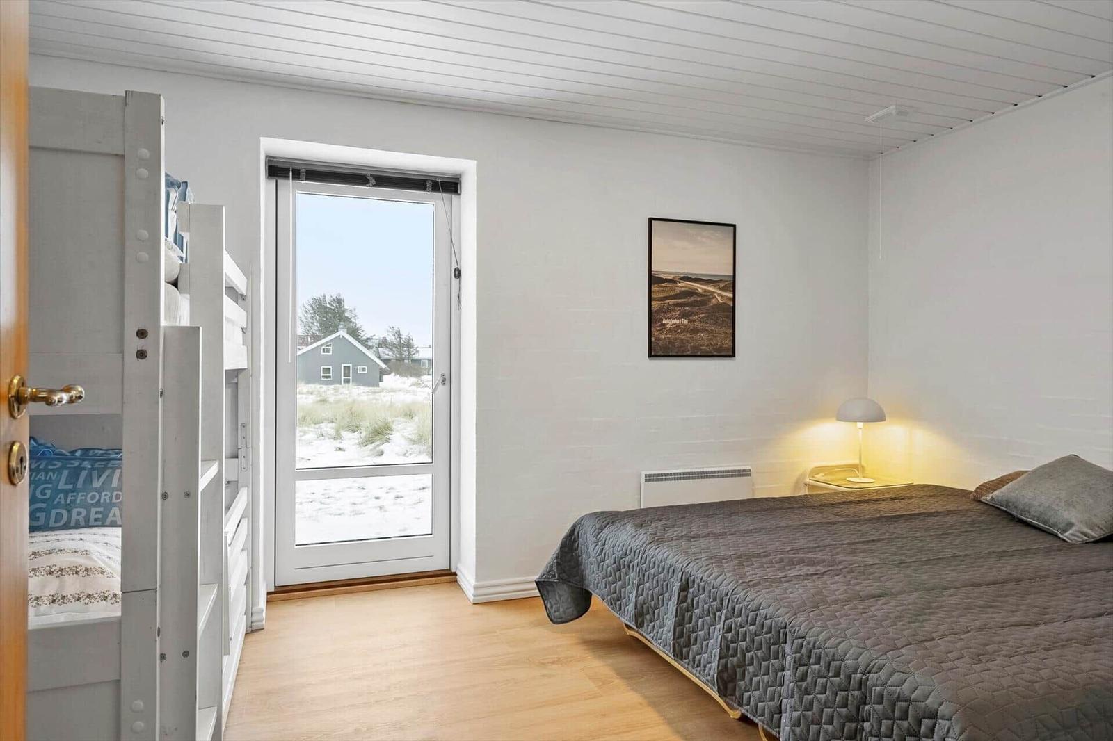 Schlafzimmer mit Doppelbett, Schlafcouch und Blick auf die Landschaft.