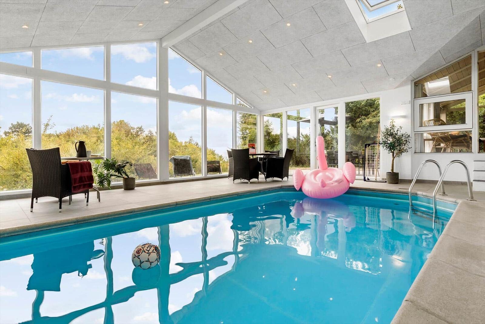 Innenpool mit großem Fensterbereich und pinkem Flamingo-Boot.