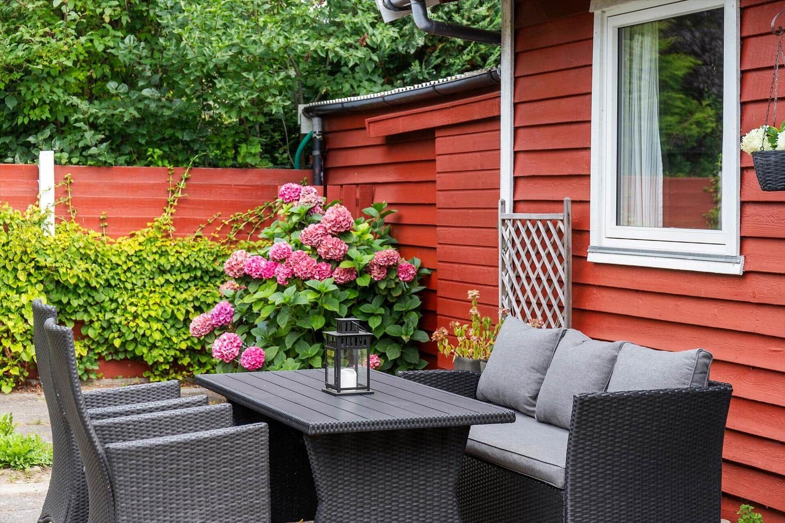 Red wooden outdoor area with seating and flowers