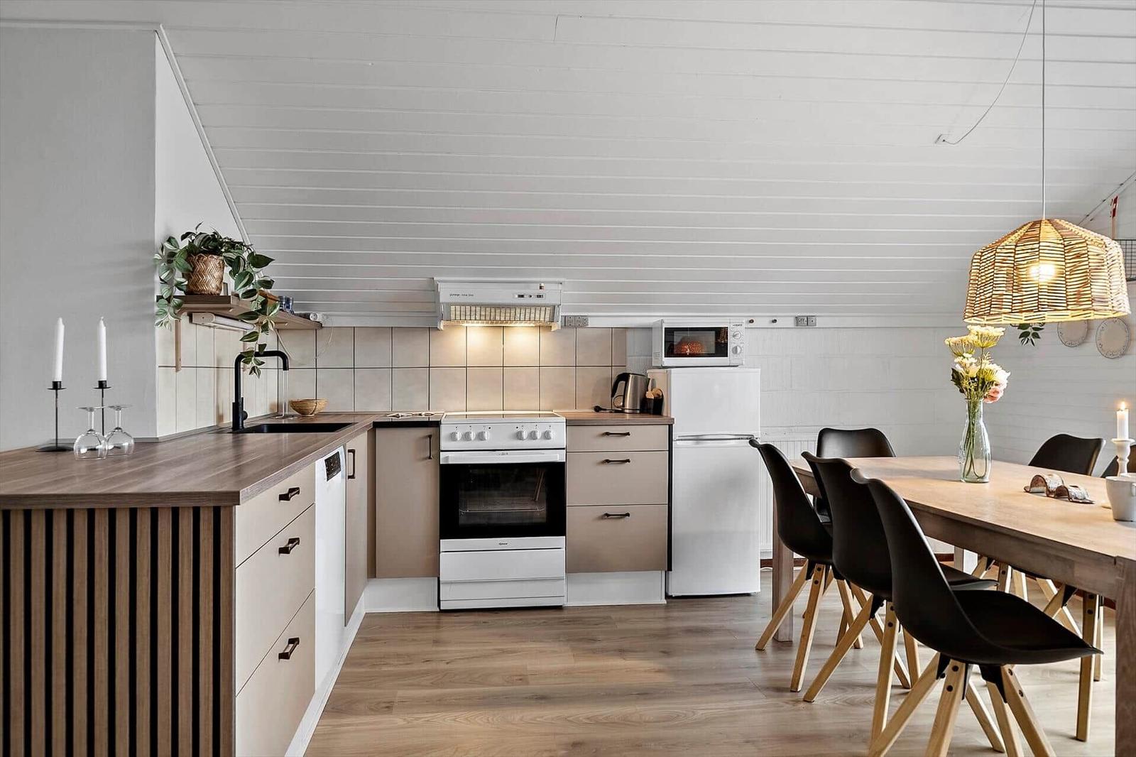Küche mit Essbereich, Holzfußboden und weißer Decke.