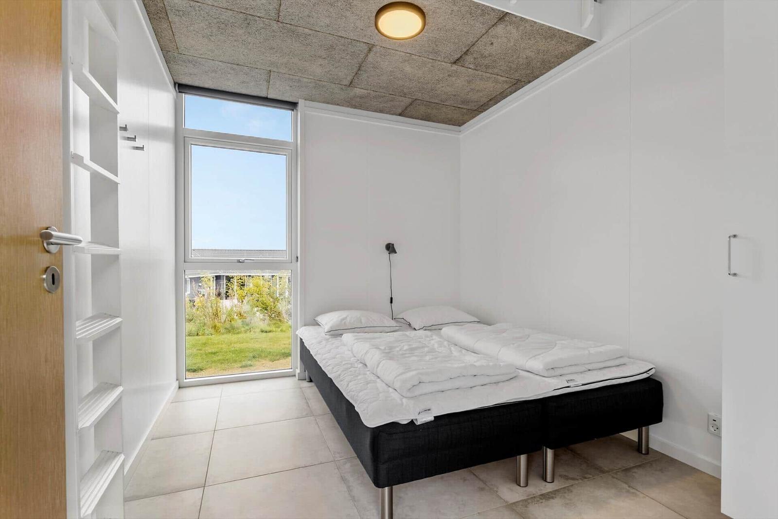 Schlafzimmer mit Bett, Fenster und Regal