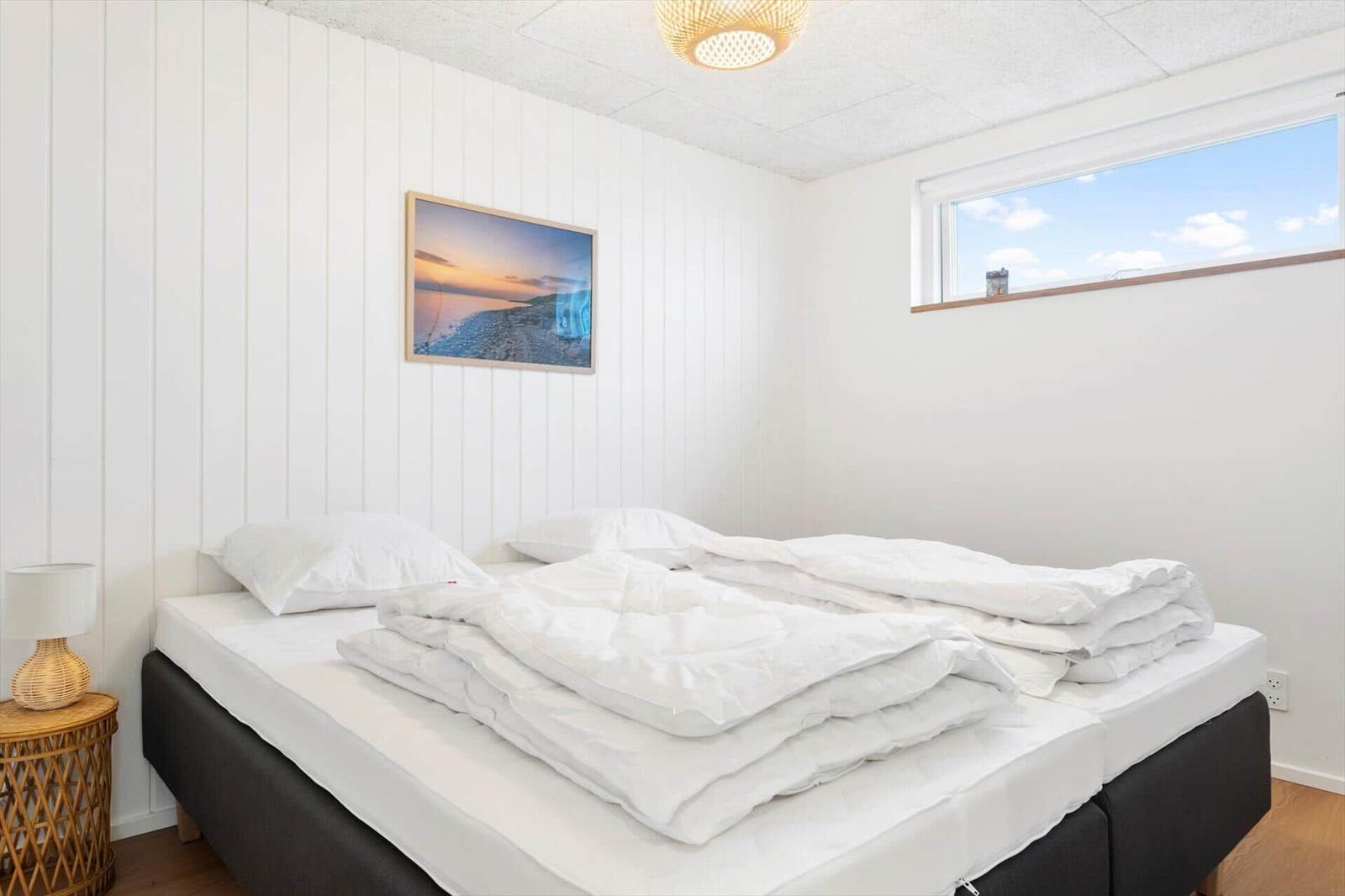 Schlafzimmer mit Bett, Fenster und Wandbild