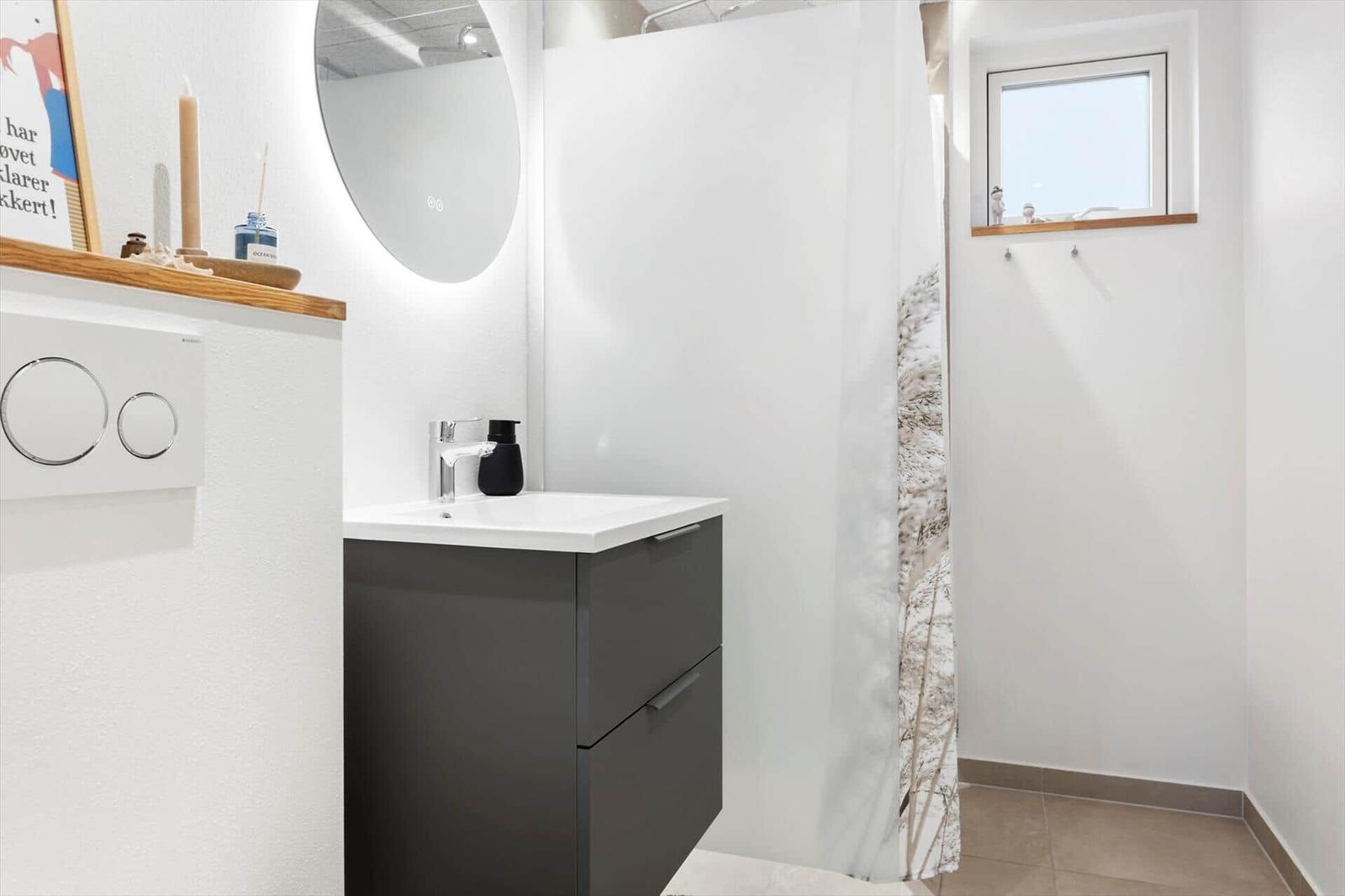 Badezimmer mit Waschbecken, Spiegel und Duschvorhang