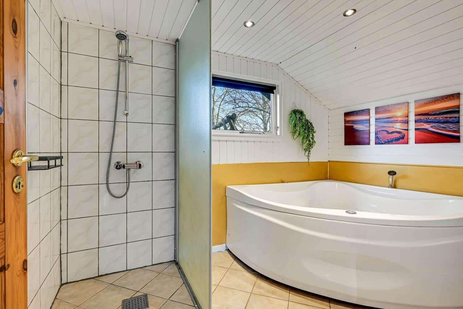 Dusche und Whirlpoolbad mit Fenster und Wandbildern