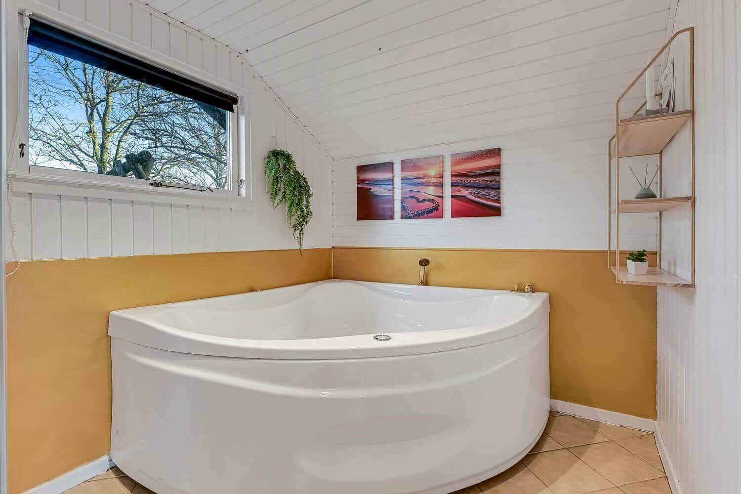 Bad mit Whirlpool, Fenster und Wandbildern.