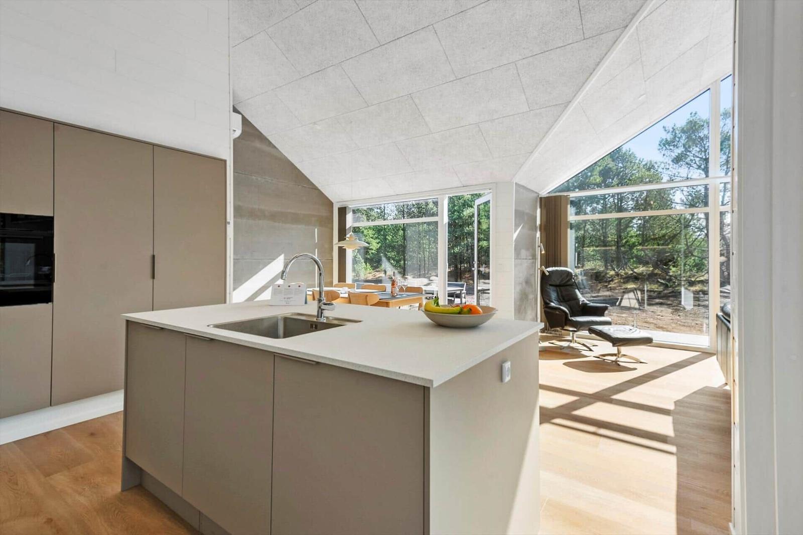 Kitchen with island and view of living area with seating.