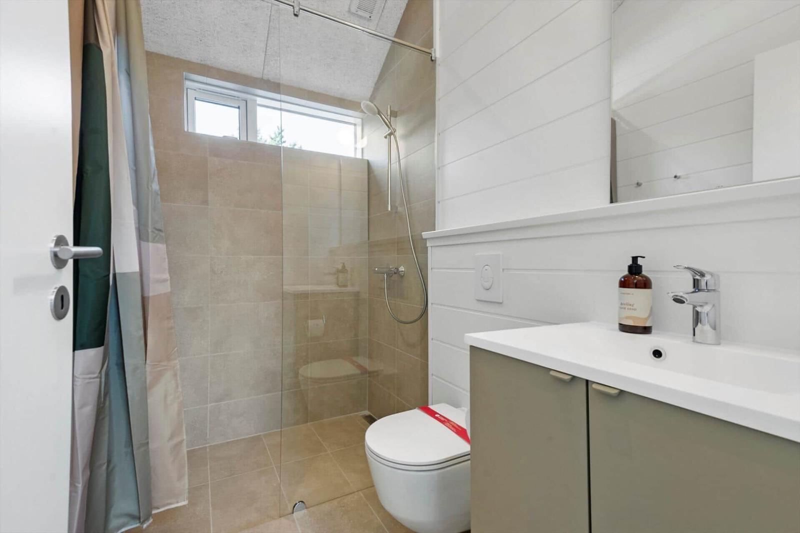 Bathroom with shower, toilet, and sink.