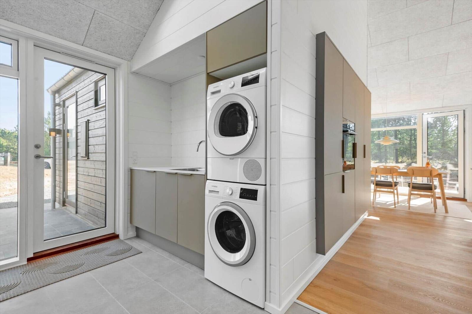 Apartment with washer and dryer, kitchenette, and view of dining area.