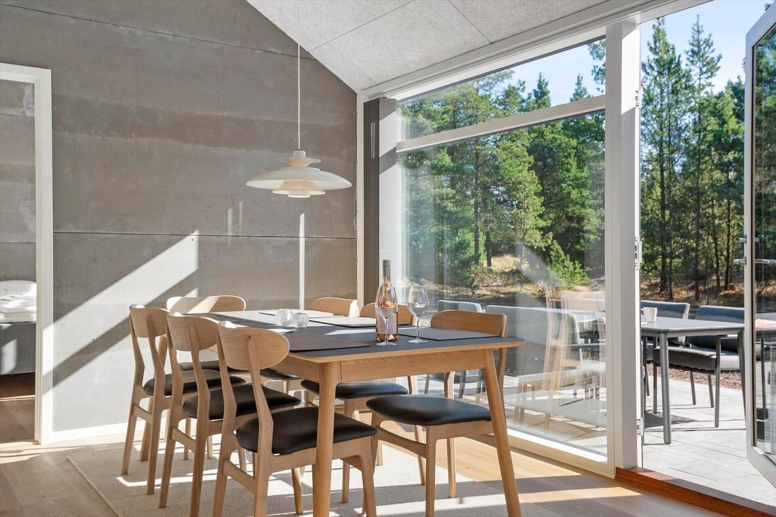 Dining area with wooden table and chairs. Large glass front to the garden.