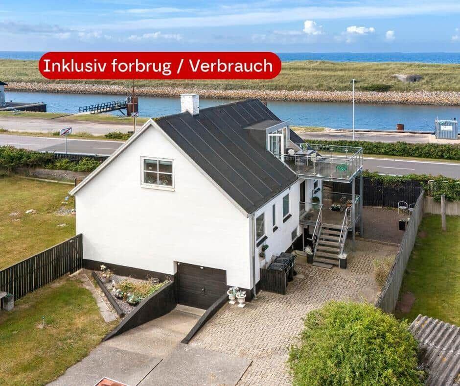 Weißes Haus mit Garage und Terrasse am Wasser