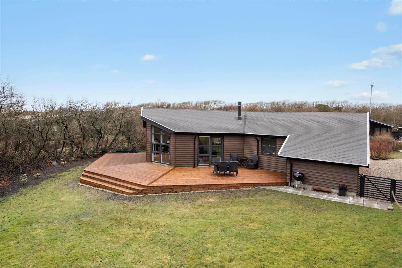 Modern cabin with wooden terrace and garden. Grill and seating area available.