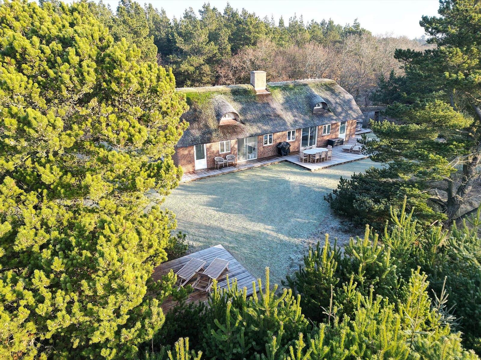 Haus mit Grashütte, Terrasse und Garten im Wald