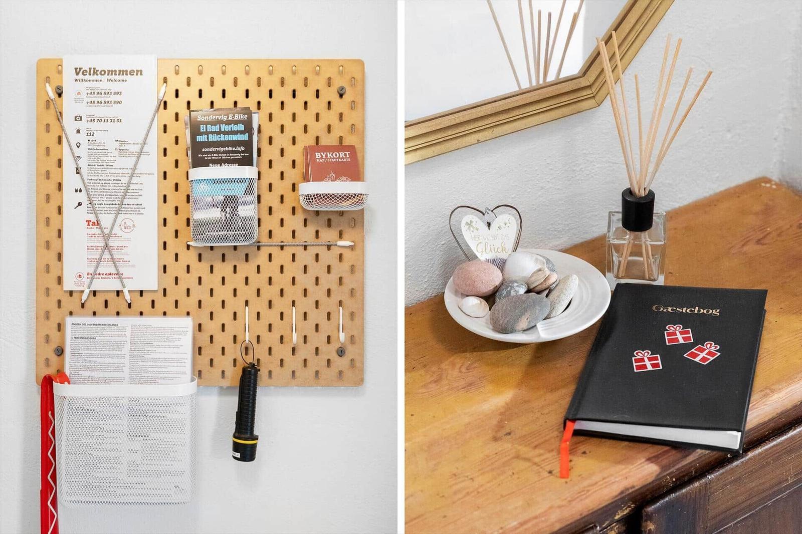 Wandorganizer mit Broschüren und Schlüssel. Holztisch mit Steinchen, Duft und Gästebuch.