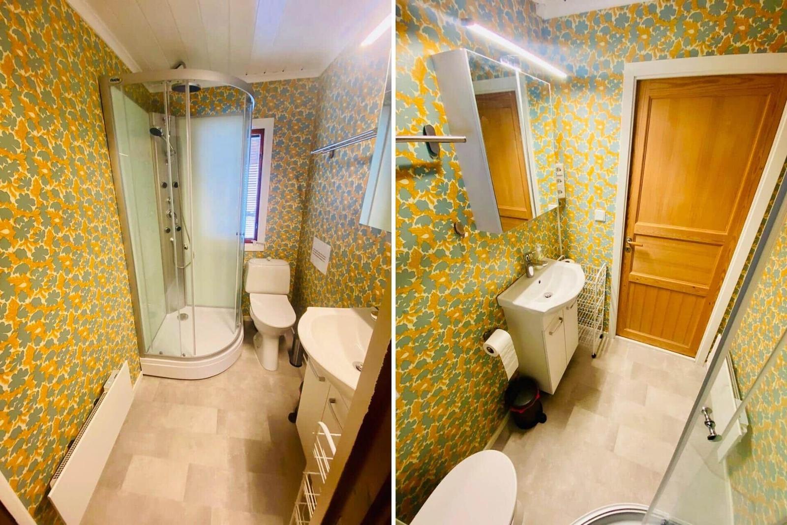 Badezimmer mit Dusche, Toilette und Waschbecken. Wandtapete in gelb-grün.
