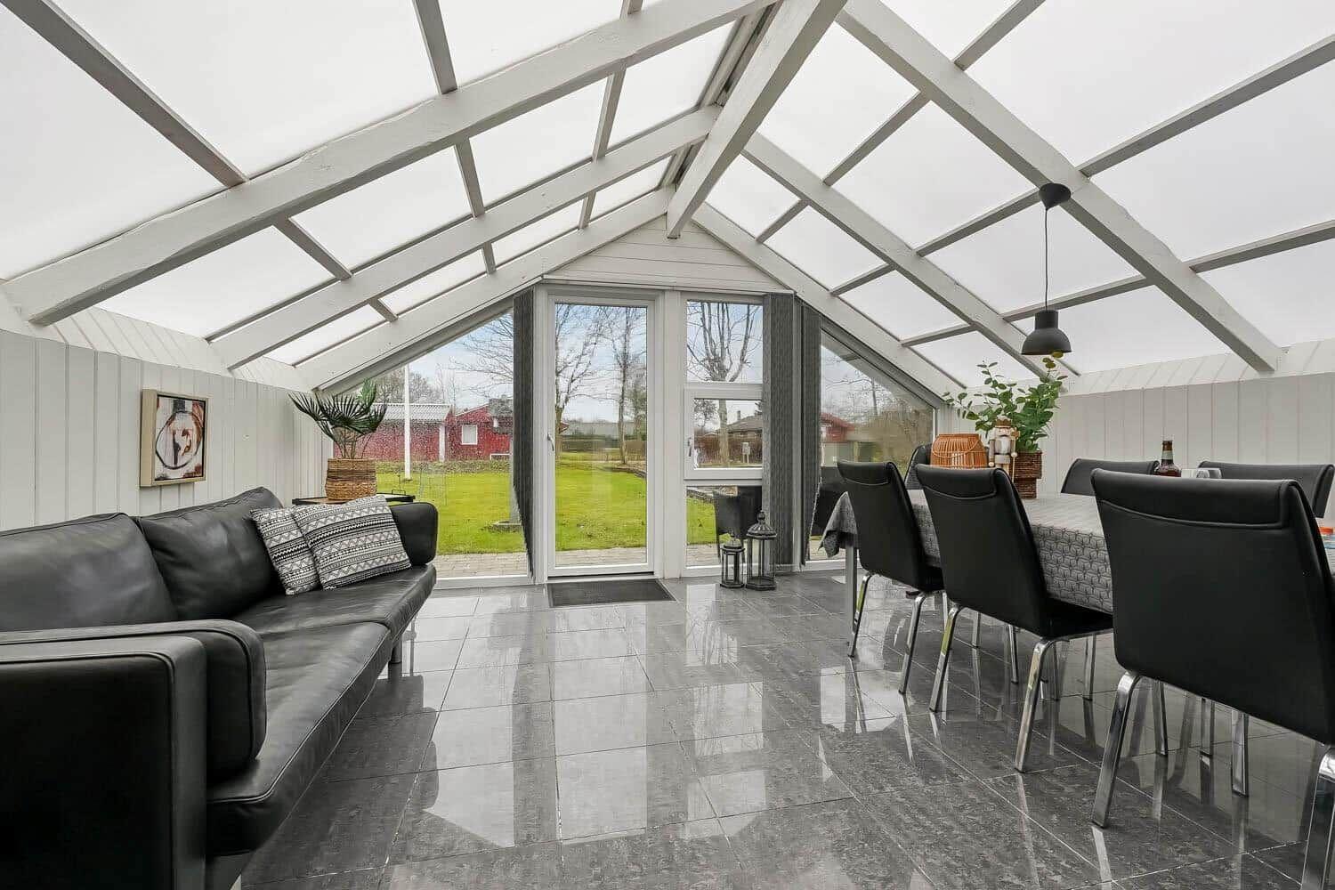 Großes Wohn- und Esszimmer mit Glasdach und Terrassentür.