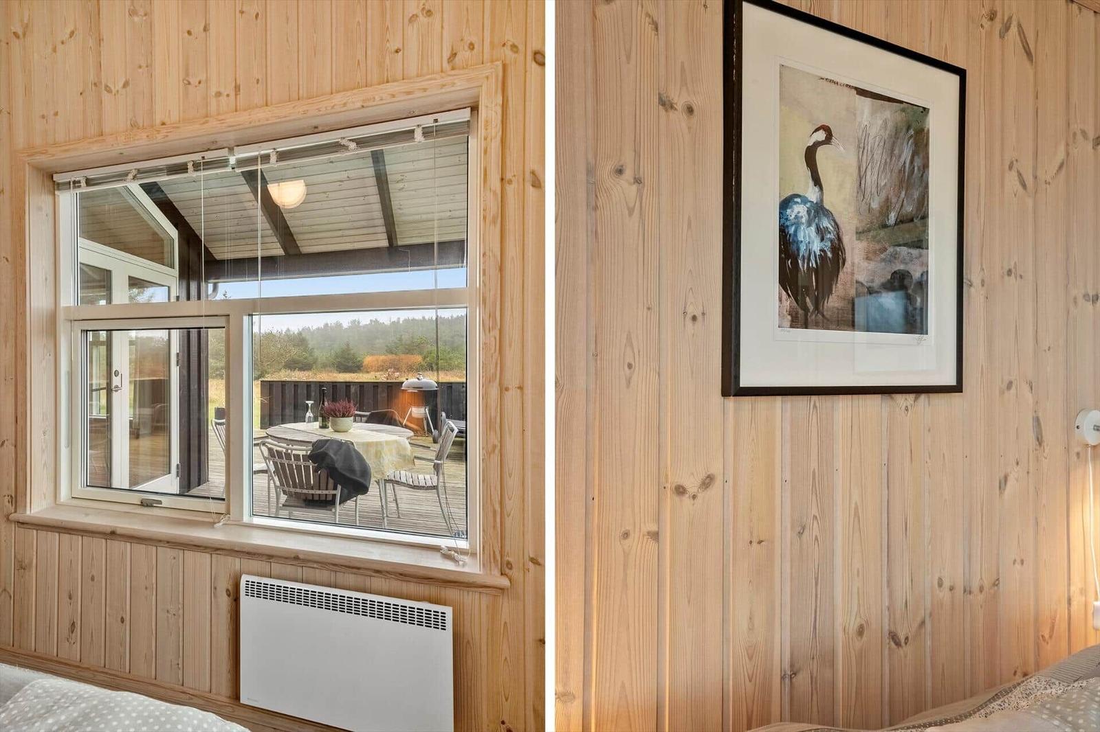 Holzwand mit Bild und Blick auf Terrasse mit Tisch und Stühlen