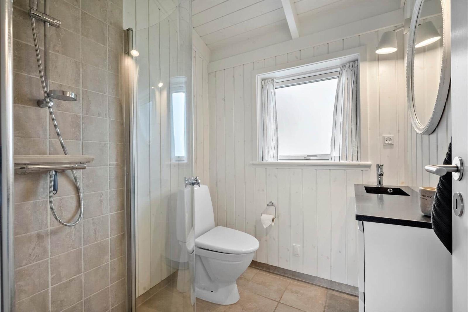 Badezimmer mit Dusche, Toilette und Waschbecken.