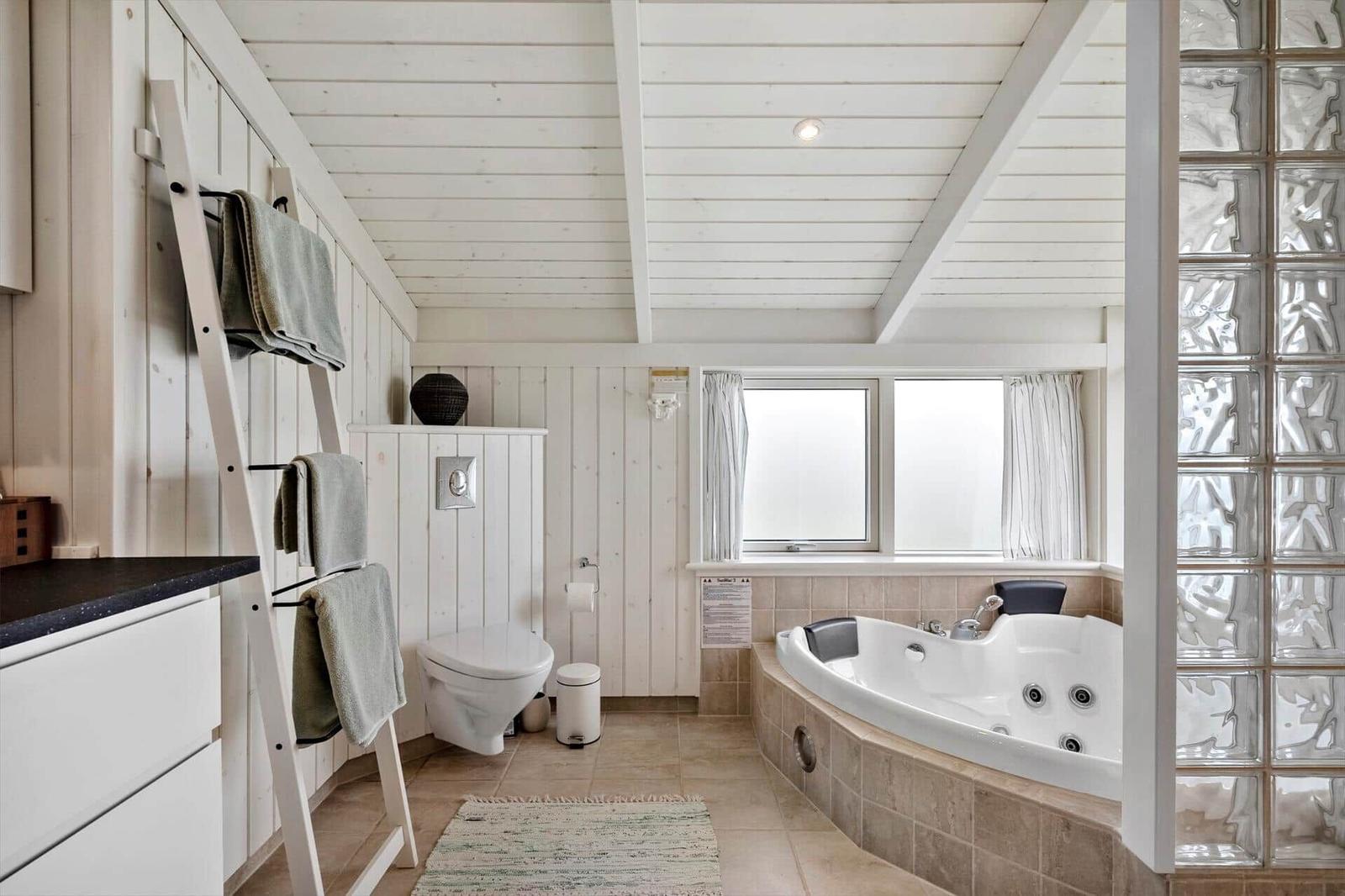 Badezimmer mit Whirlpool, Toilette und Handtuchständer