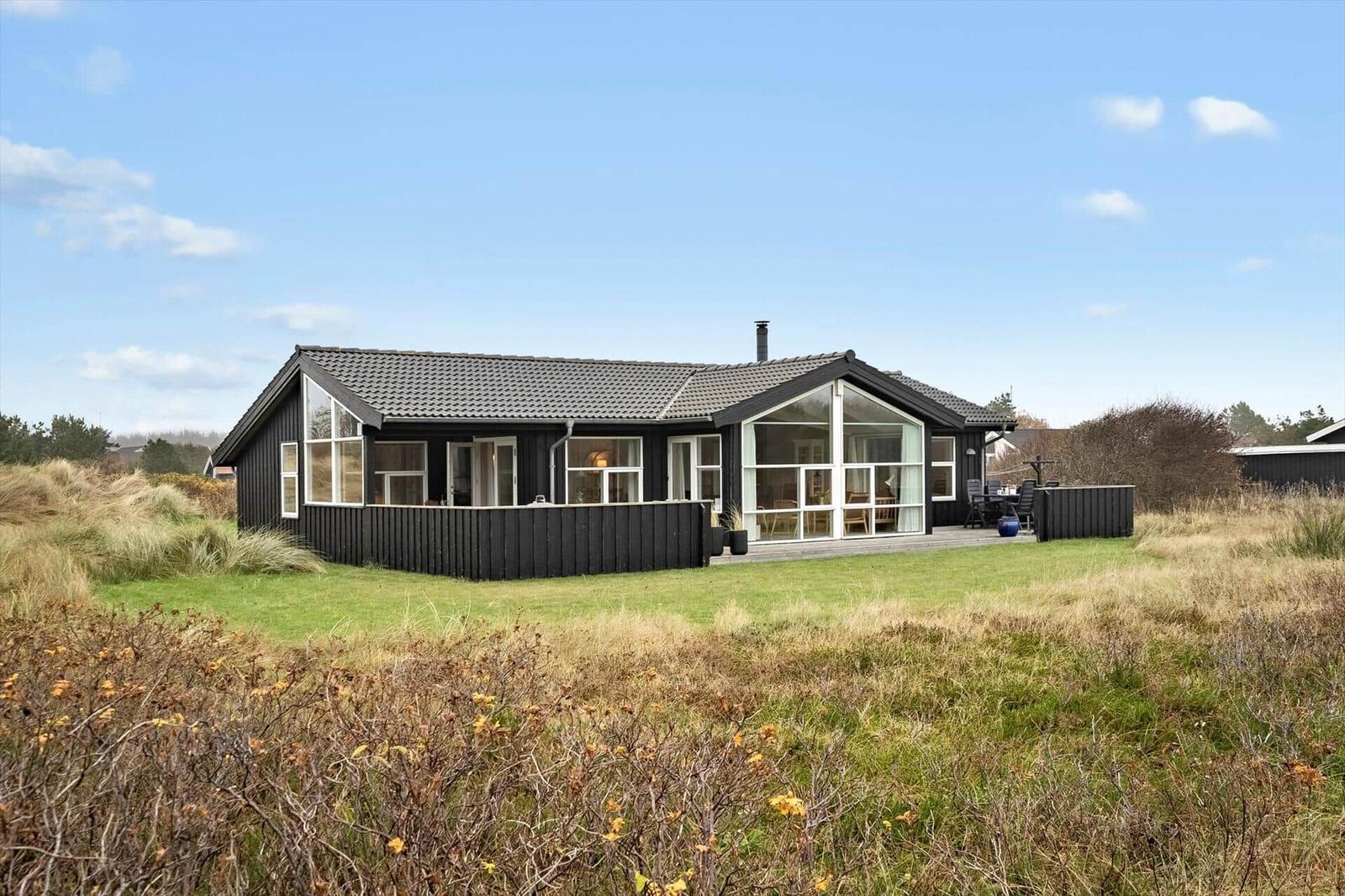 Ein modernes Haus mit großem Glasbereich und Terrasse im Freien.