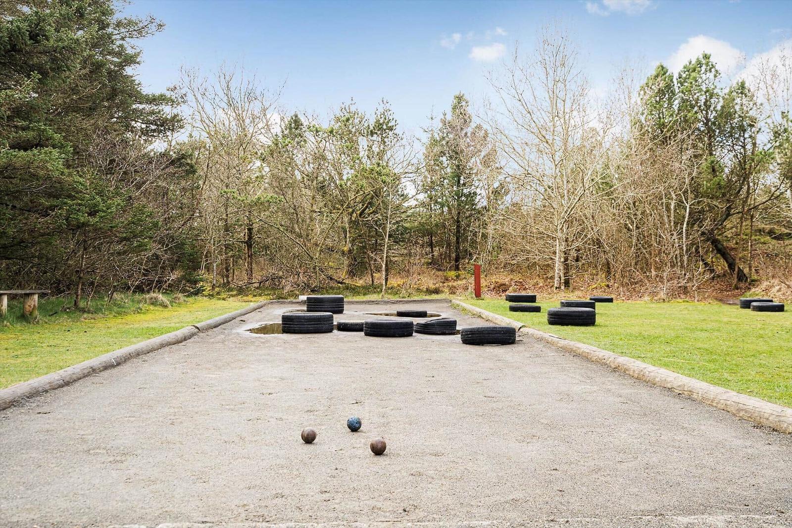 Pétanque-Brett mit Reifen und Bällen im Gras.