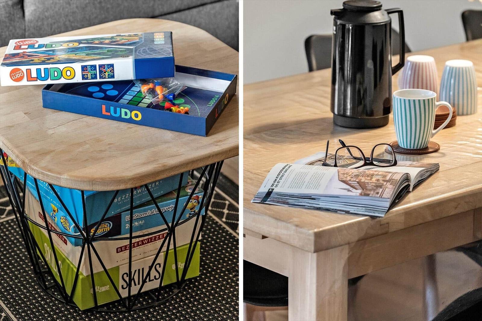Holztisch mit Brettspielen und Kaffeetasse. Tisch mit Zeitschrift und Brille.