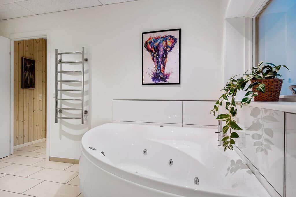 Bath with whirlpool, wall heater, and wall art