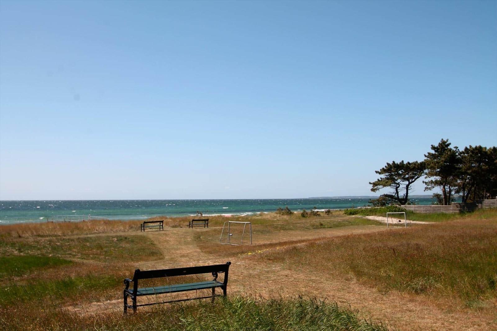 Strandufer mit Bänken und Fußballtor im Grasland.