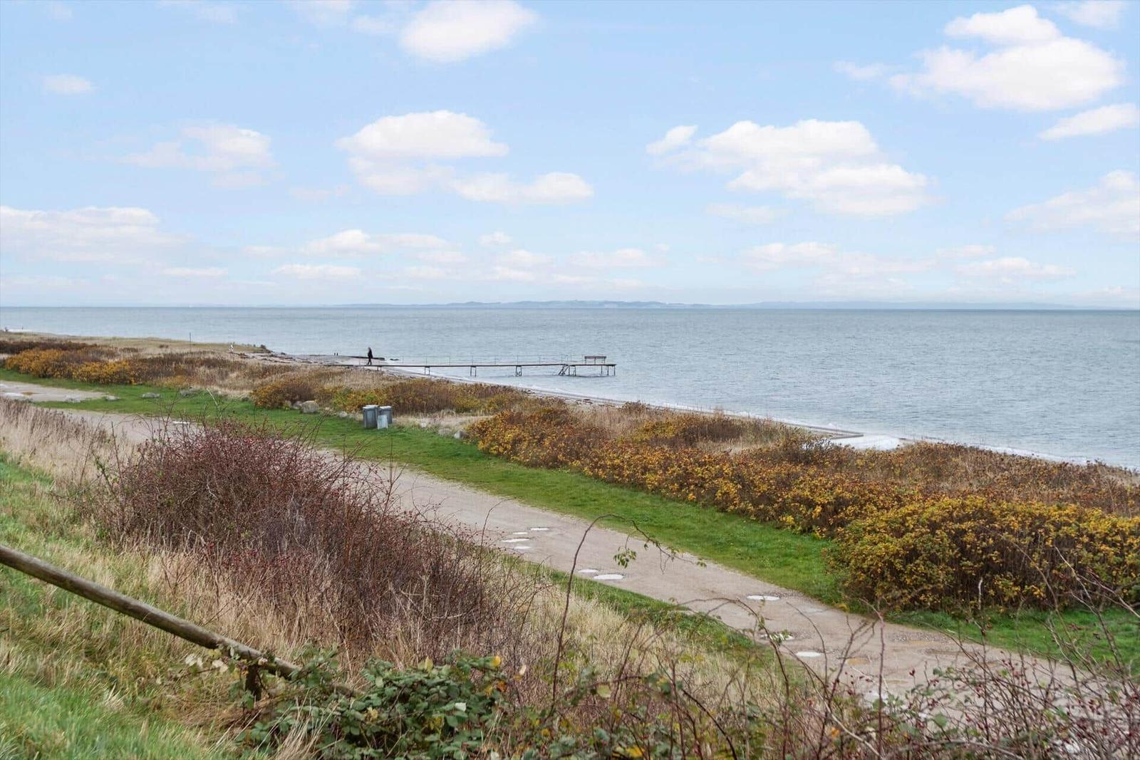 Wanderweg entlang Küste mit Steg zum Meer