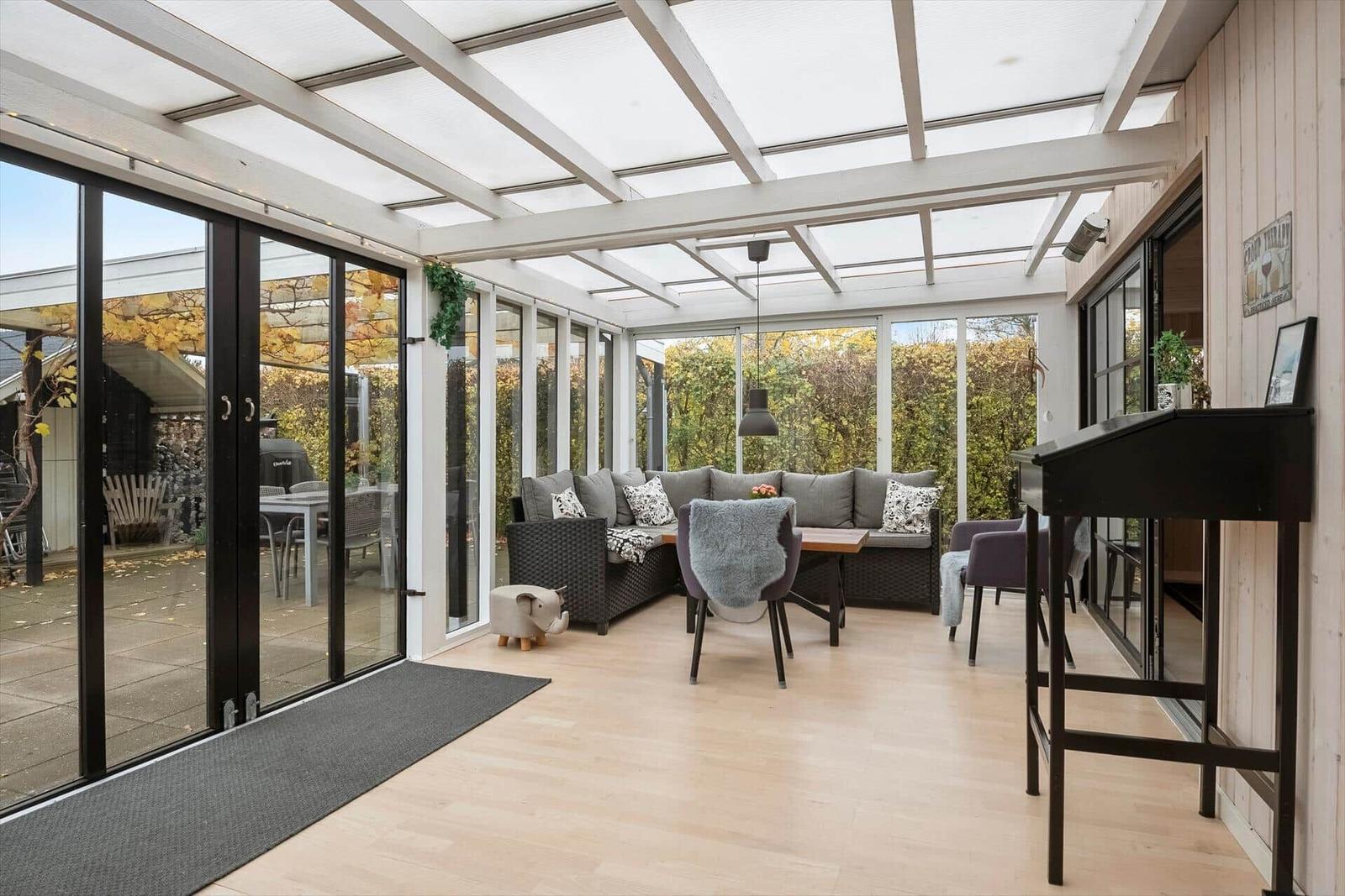 Glasdach mit Sitzbereich und Türen zur Terrasse