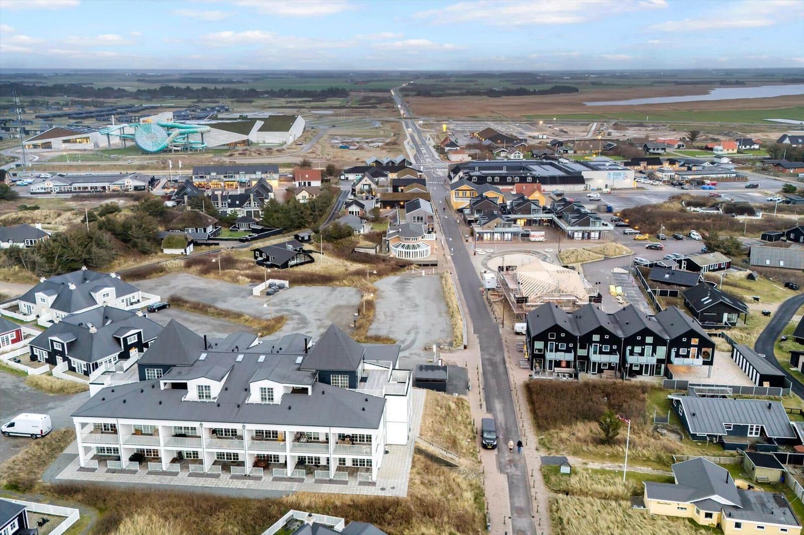 Aerial view of a coastal resort with modern buildings and a water park.