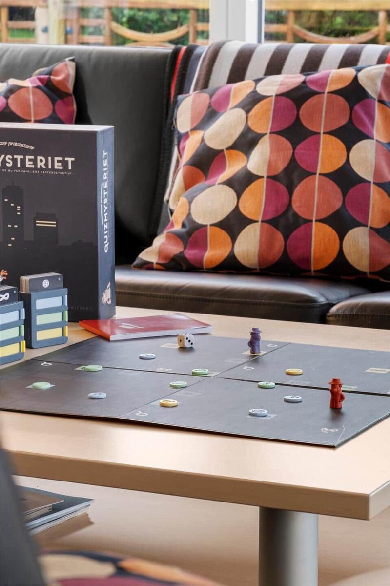 Ein Tisch mit einem Spiel und einem Sofa mit Kissen.