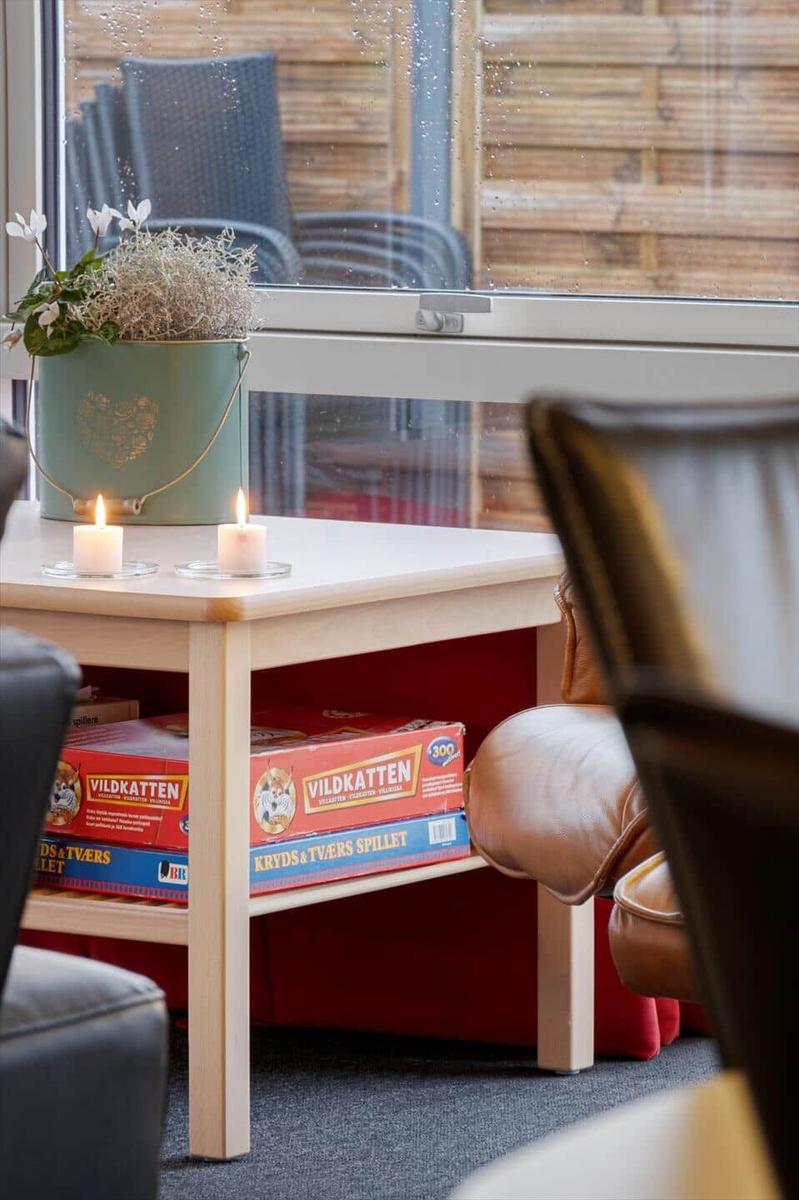 Tisch mit Kerzen und Spielboxen vor Fenster