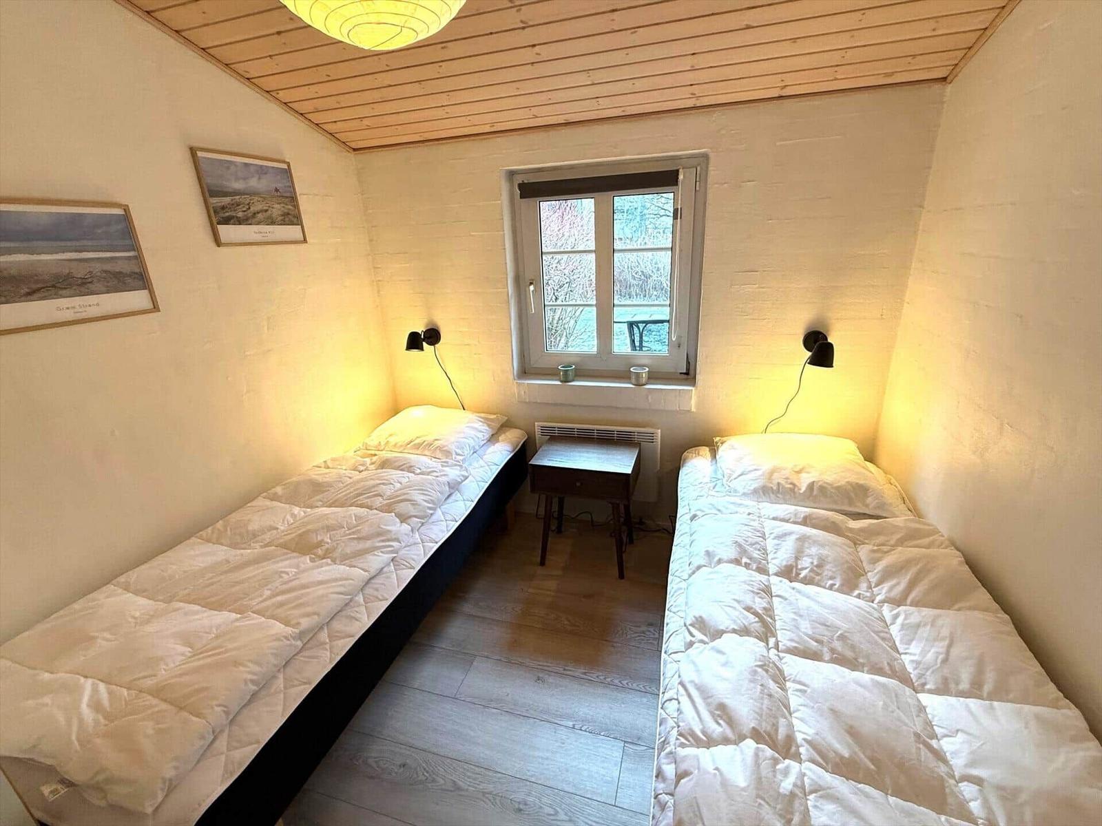Zwei Schlafplätze mit Betten, Fenster und Tisch.