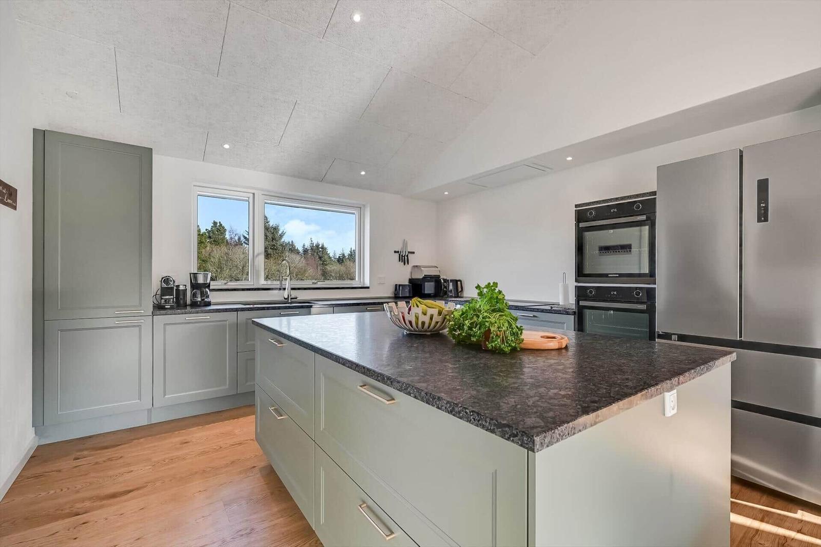 Modern kitchen with island, stainless steel appliances, and hardwood flooring.