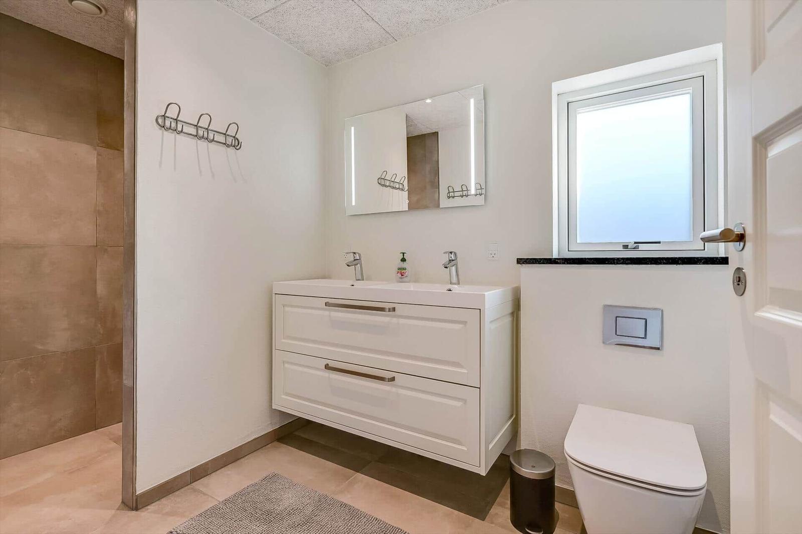 Bathroom with sink, mirror, toilet, and shower.