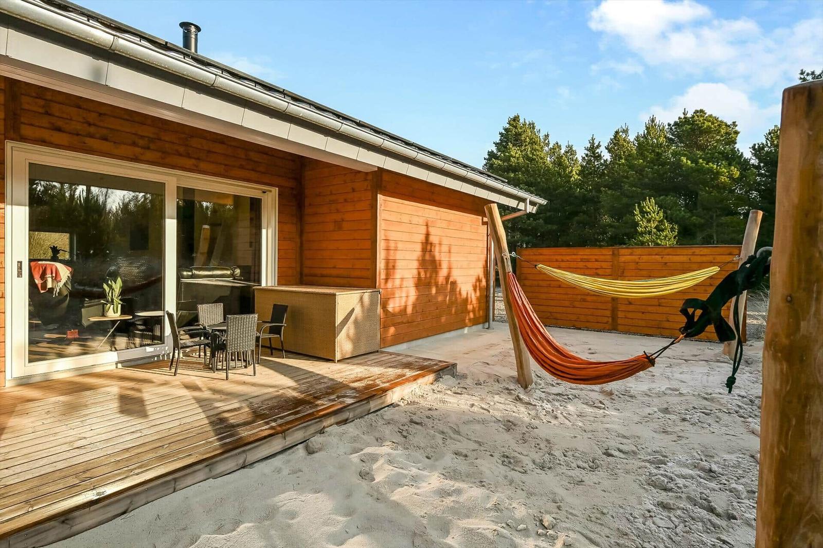 House with terrace, sandy area, and two hammocks.