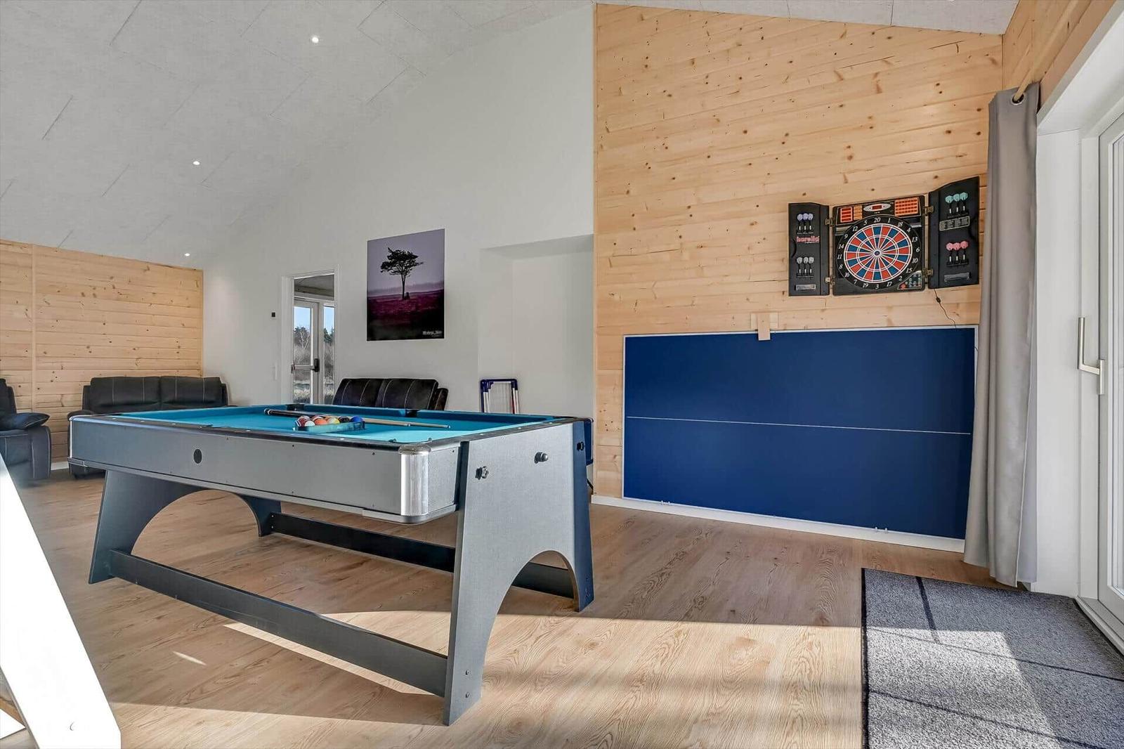 Room with pool table, dartboard, and ping pong wall.