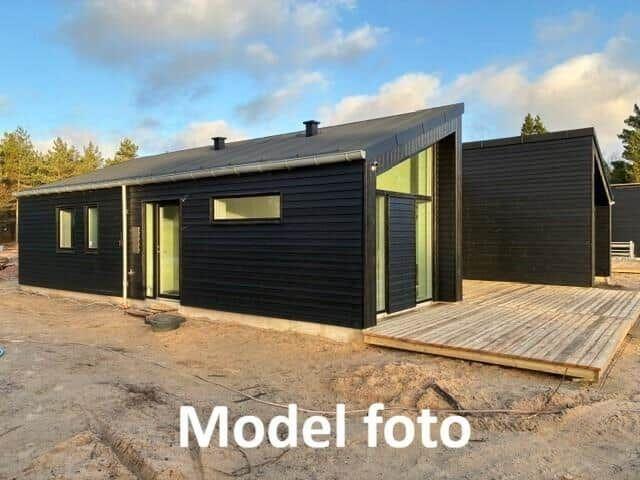 Modern wooden cabin with terrace and large window. Model photo.
