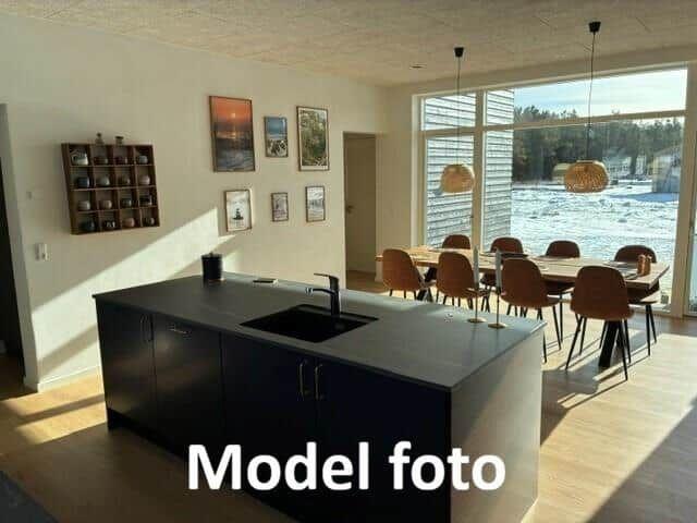 Modern kitchen with dining area and water view.