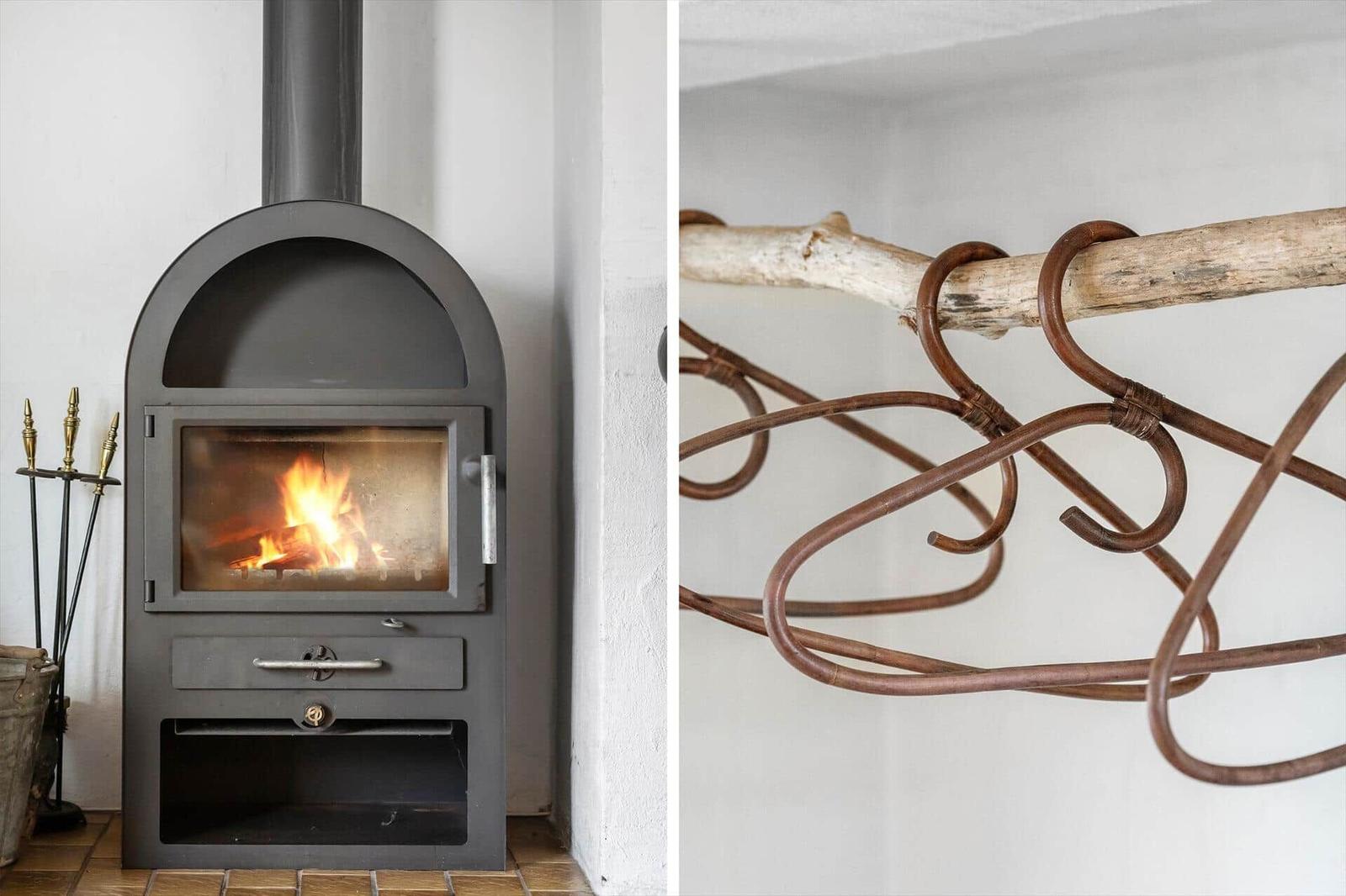 Holzofen mit Flamme und rustikale Metallkonstruktion an Wand
