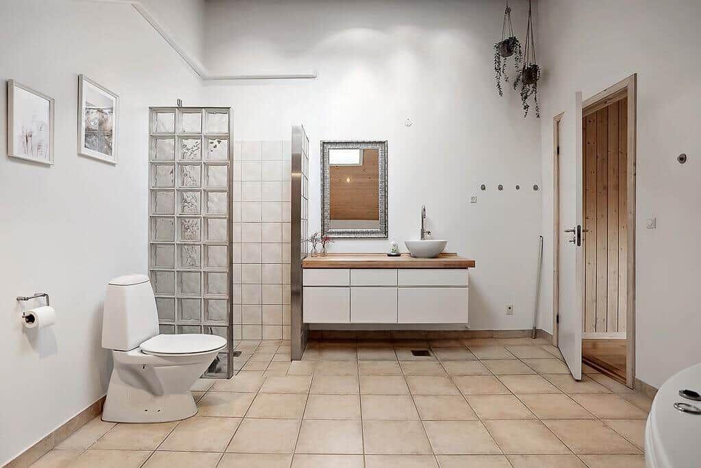 Bathroom with toilet, sink, and shower made of glass blocks.