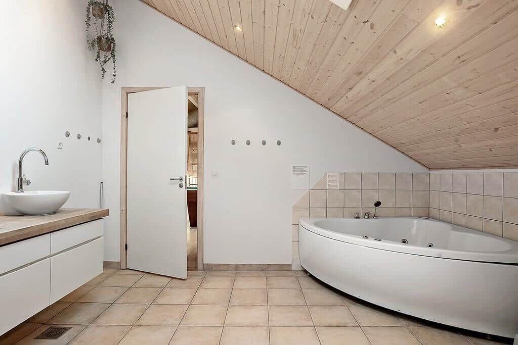 Bathroom with bathtub, sink, and wooden ceiling
