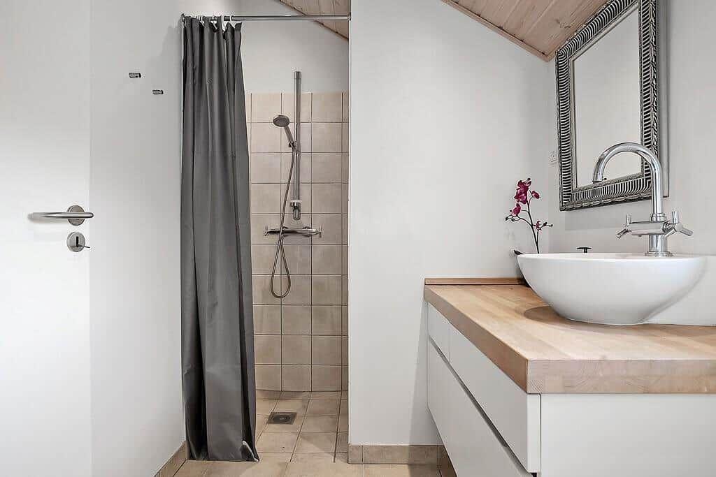 Bathroom with shower, sink, and mirror