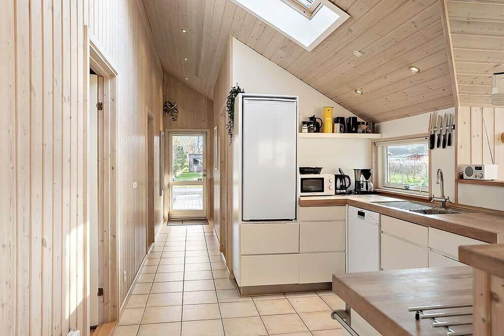 Kitchen with wooden wall, refrigerator, and window