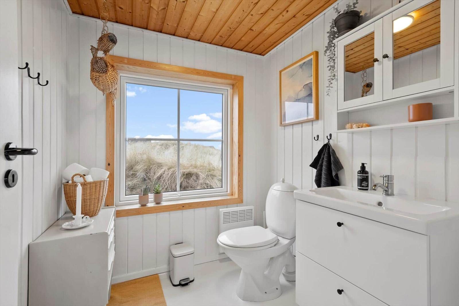 Badezimmer mit Fenster, Toilette und Waschbecken