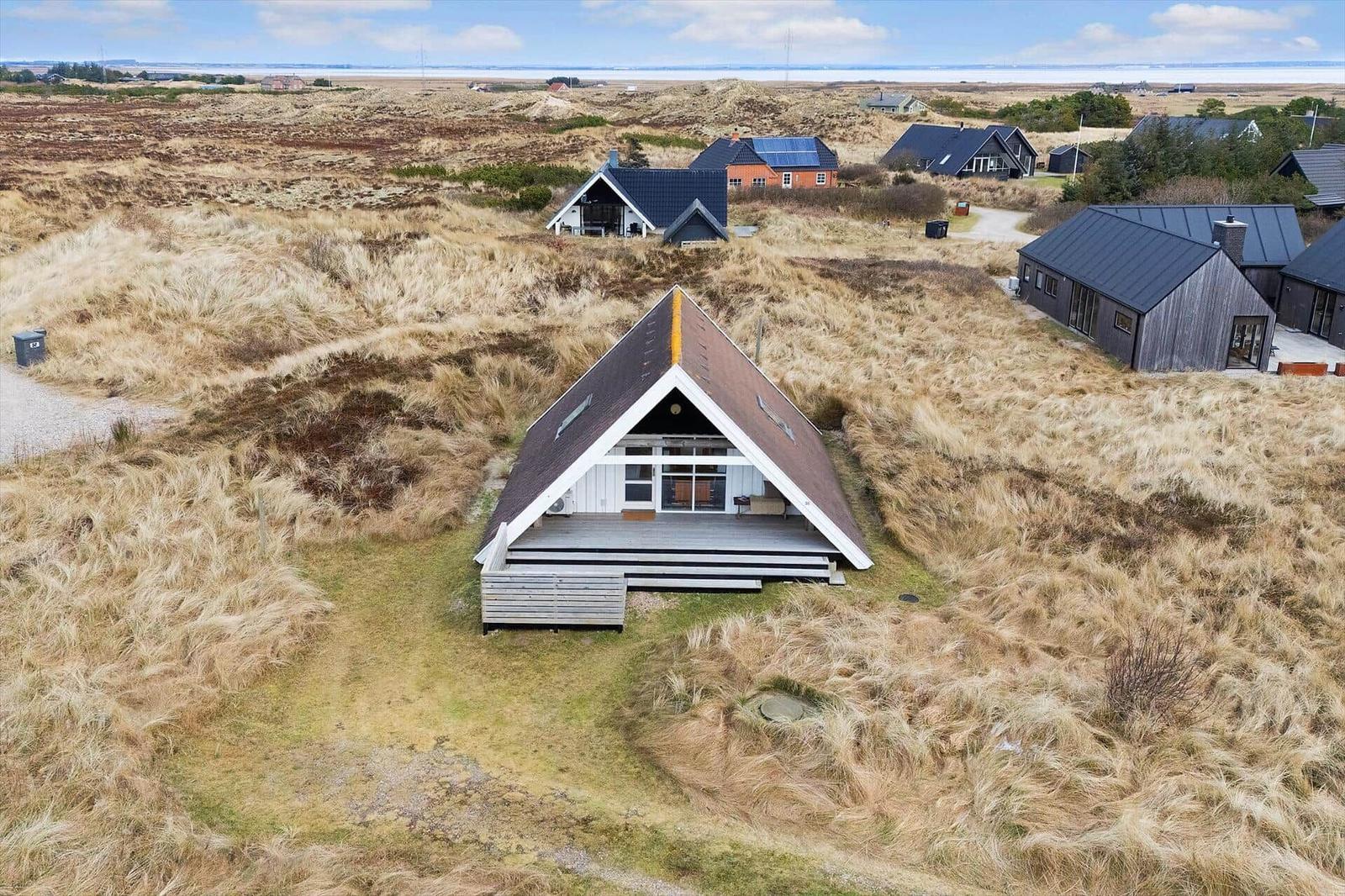 Haus mit Holzterrasse in Dünenlandschaft