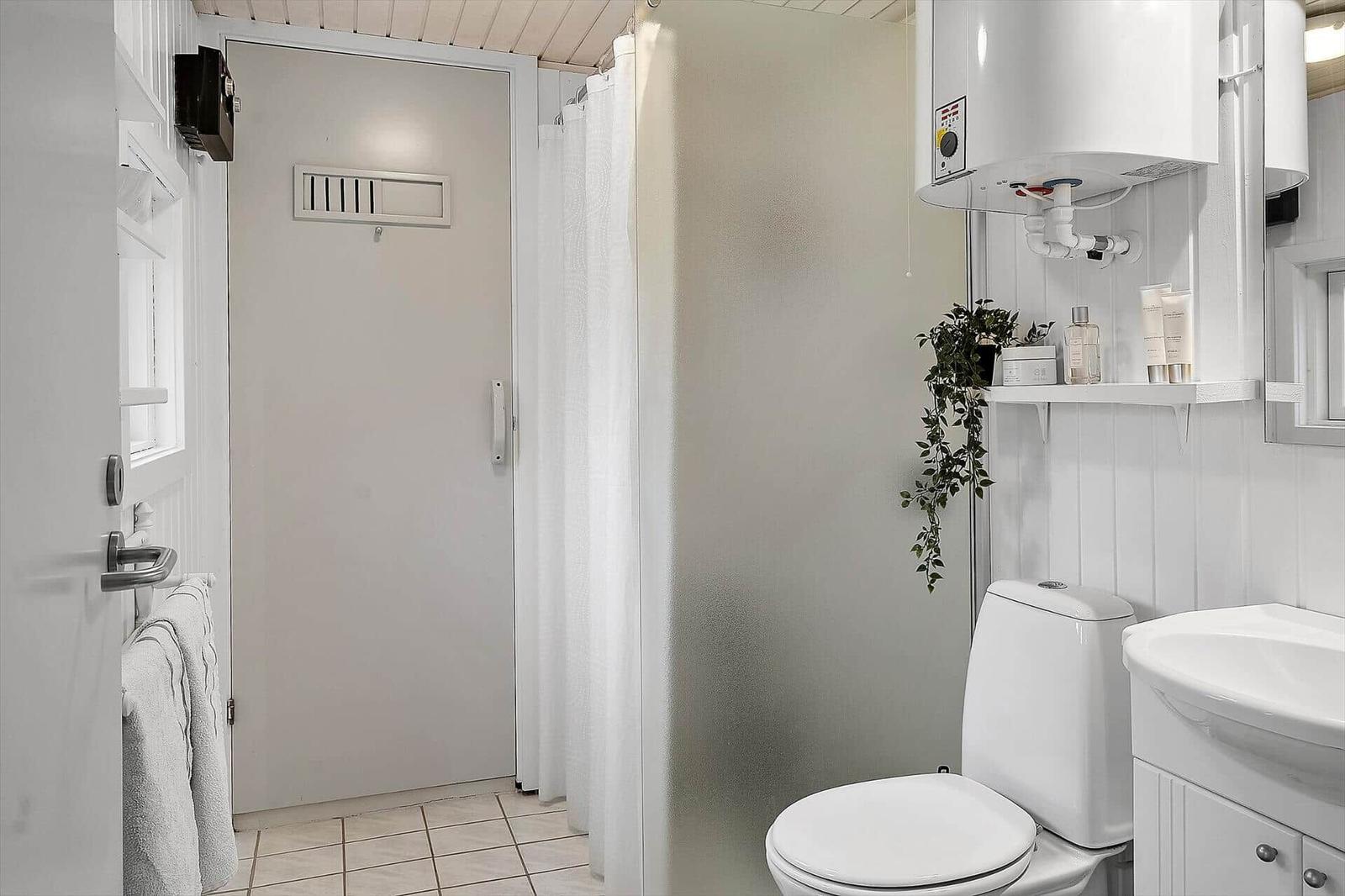 Bathroom with toilet, sink, and shower with curtain.