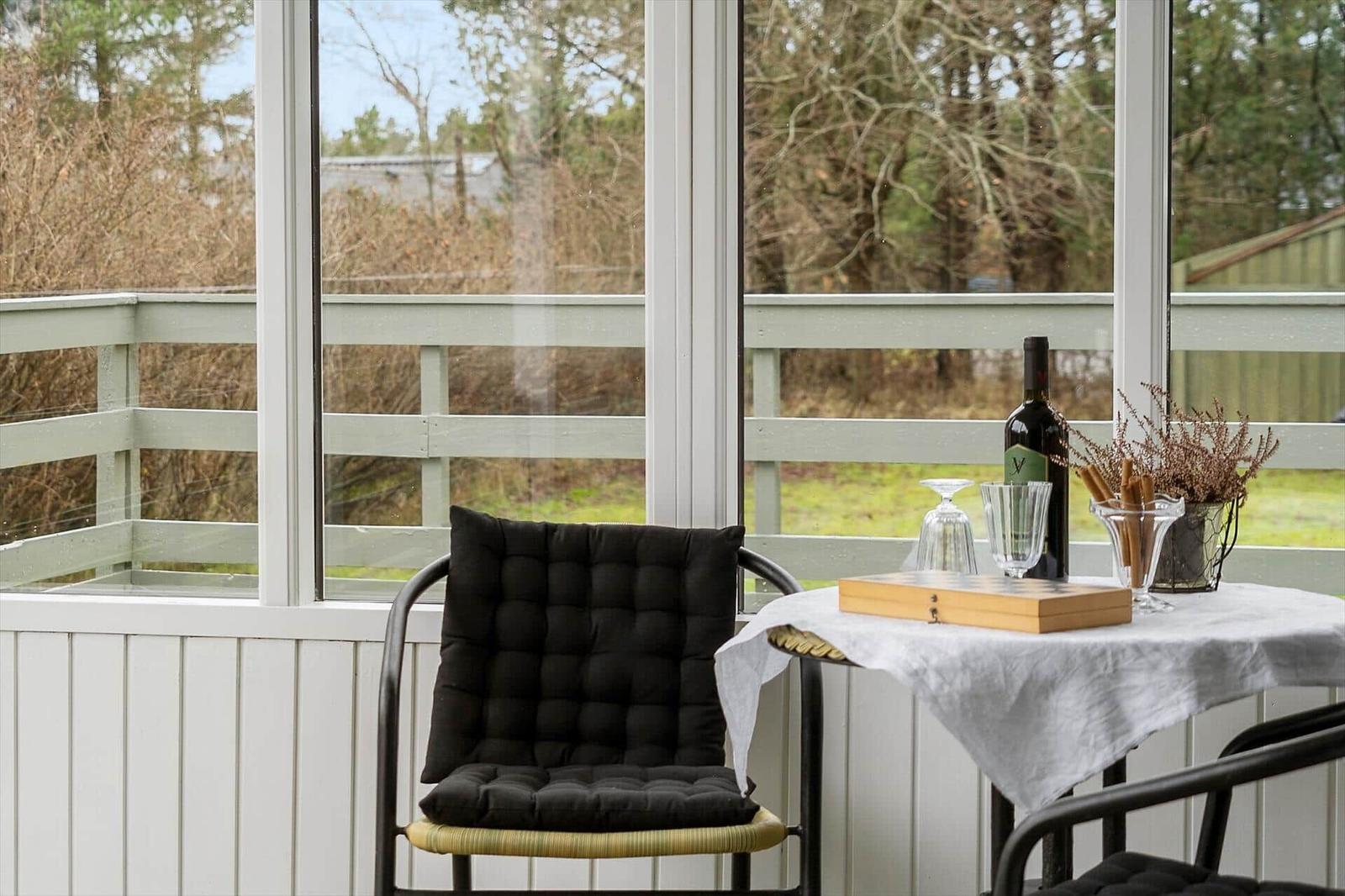 Terrace with chair, table, and wine bottle by window