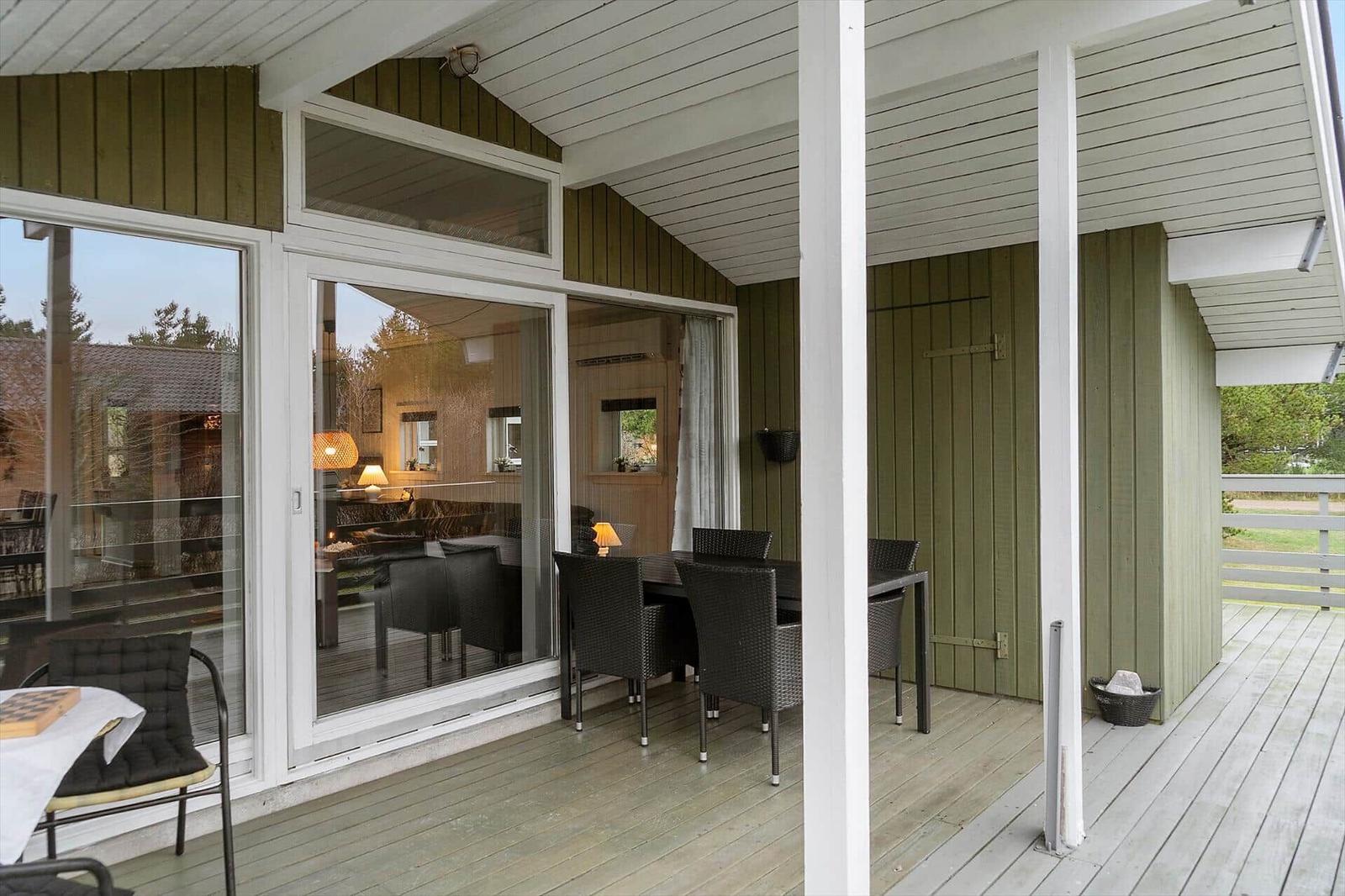 Deck with table and chairs, large sliding glass doors to interior.